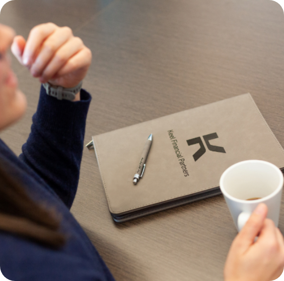 Financial planning client sitting at desk with a notebook and cup of coffee