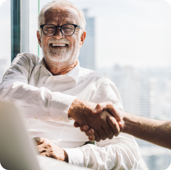 elderly gentleman shaking hands with certified financial planner