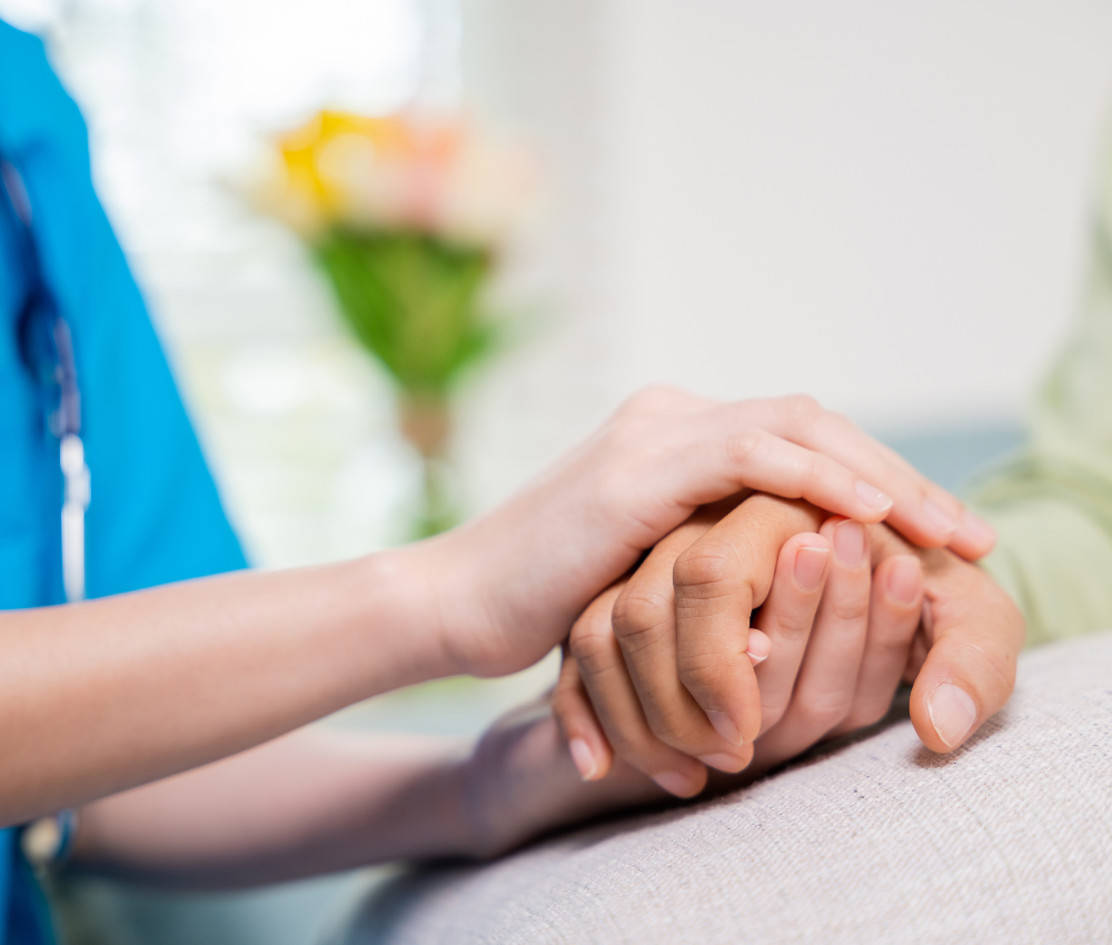 caregiver holding hands with elderly person with dementia care