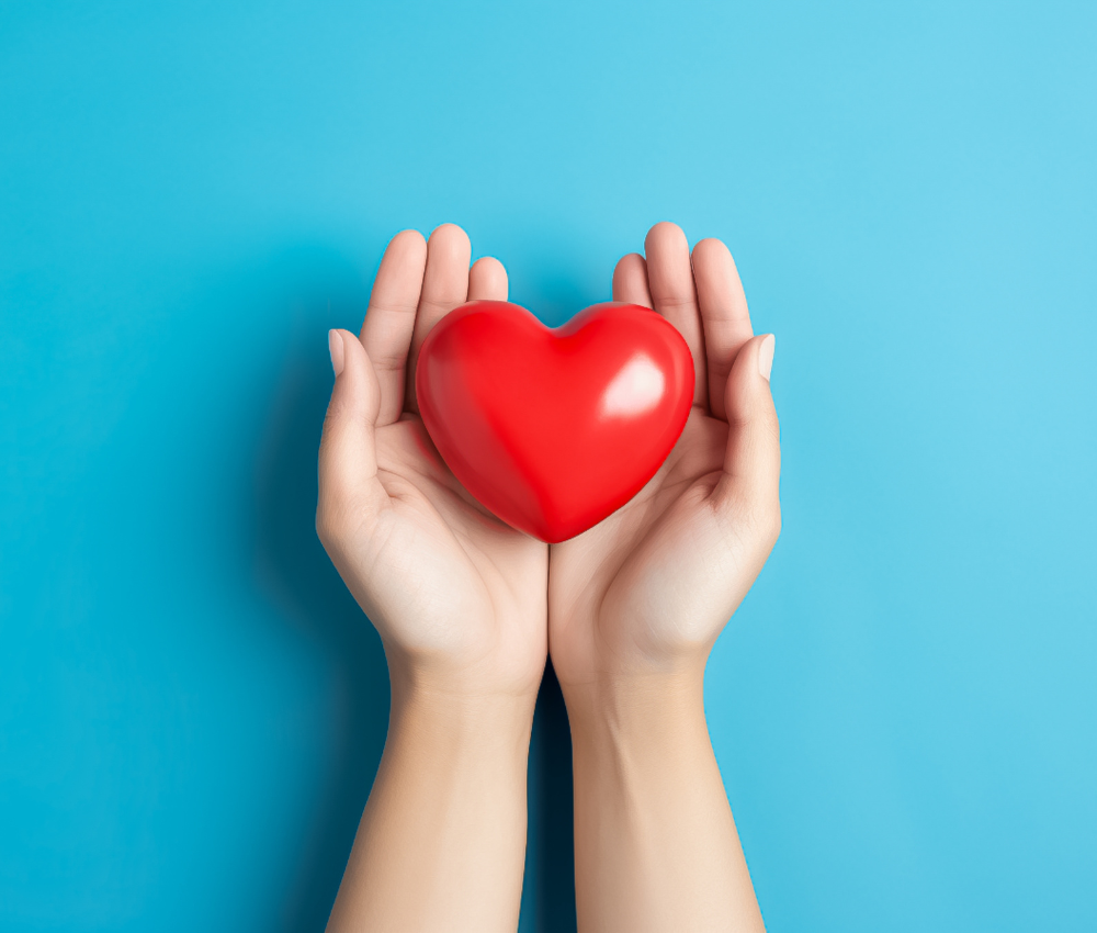 A hand holding a toy heart against a blue background on a blog about charitable giving