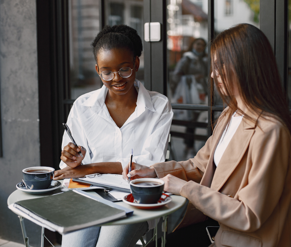 Two young professionals discussing financial strategies at a cafe