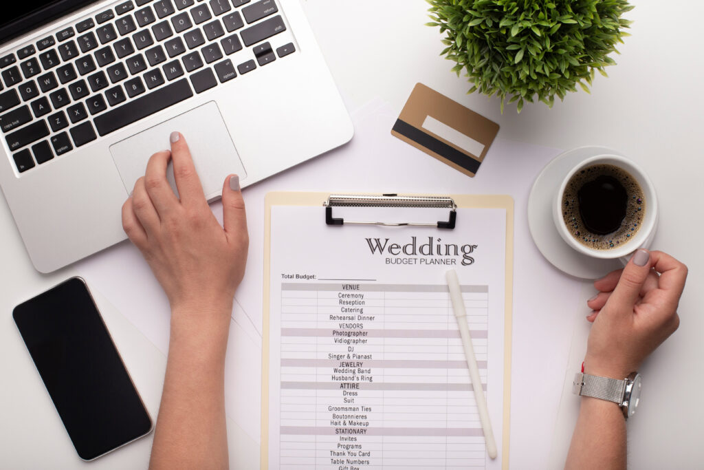 A person's workspace with a clipboard that has wedding season items on it