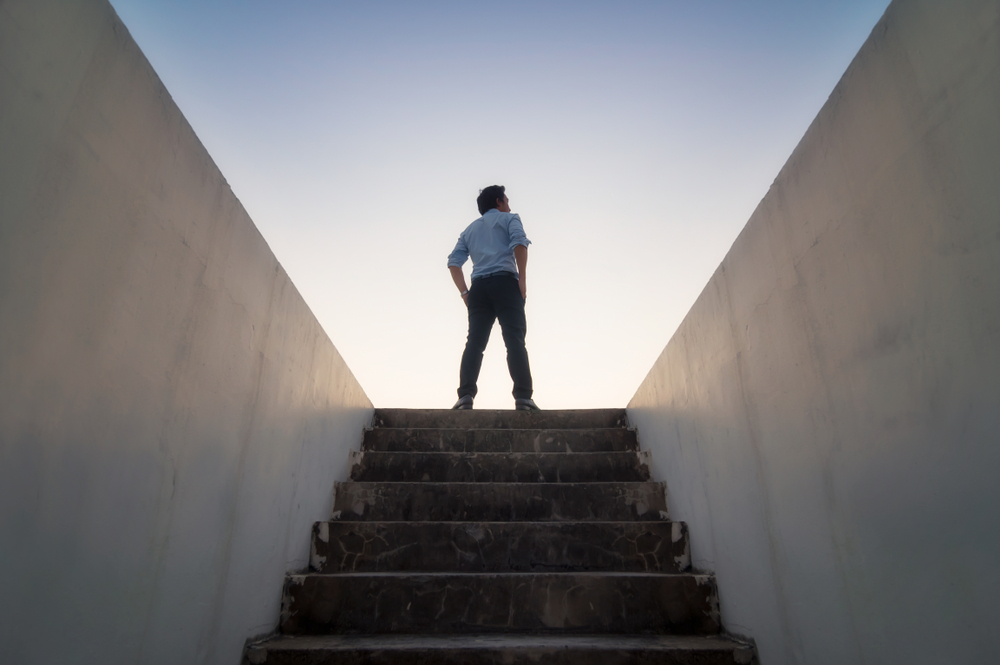 A person standing at the top of the stairs on a blog about financial independence