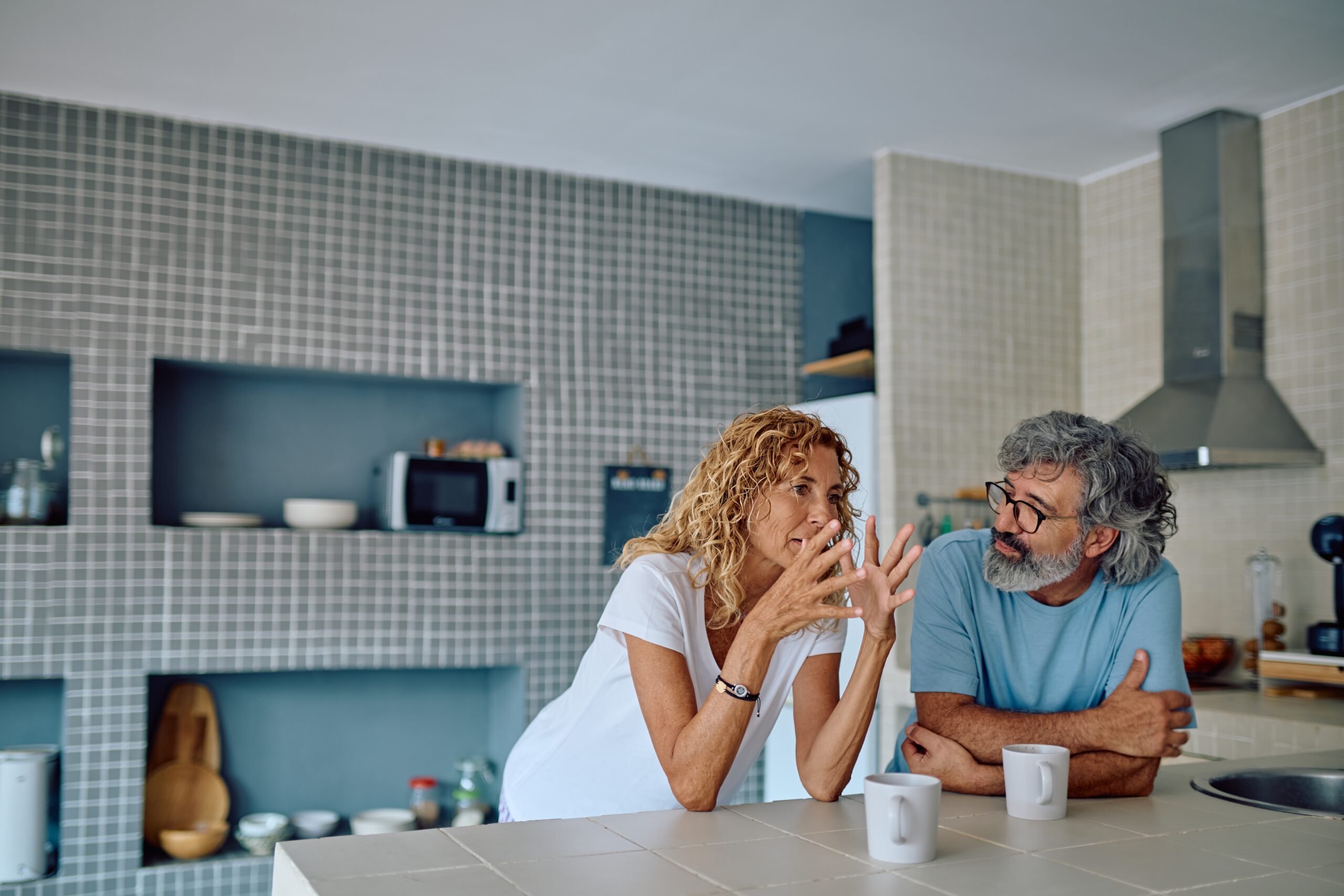 two people in a kitchen discussing financial anxiety