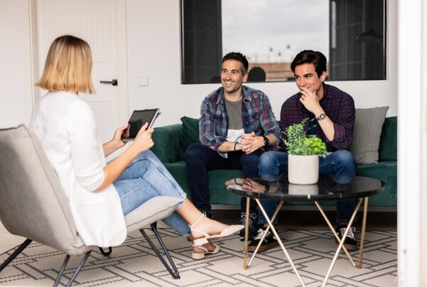 A LGBTQ+ couple sitting and planning for financial guidance for LGBTQ individuals and families