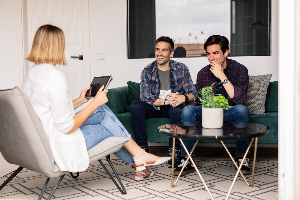 A LGBTQ+ couple sitting and planning for financial guidance for LGBTQ individuals and families